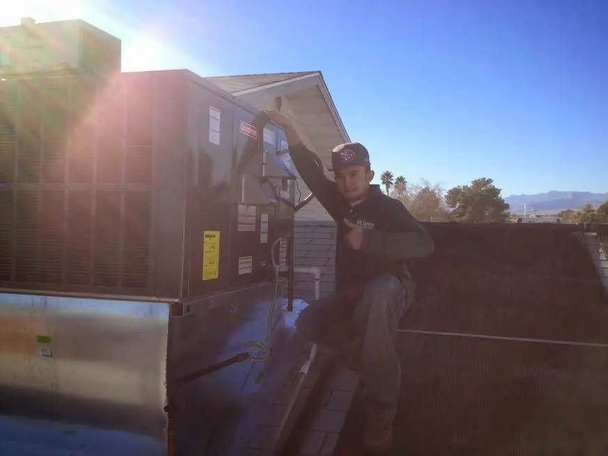 HVAC technician performing AC Tune-Up on a rooftop unit in South Gate